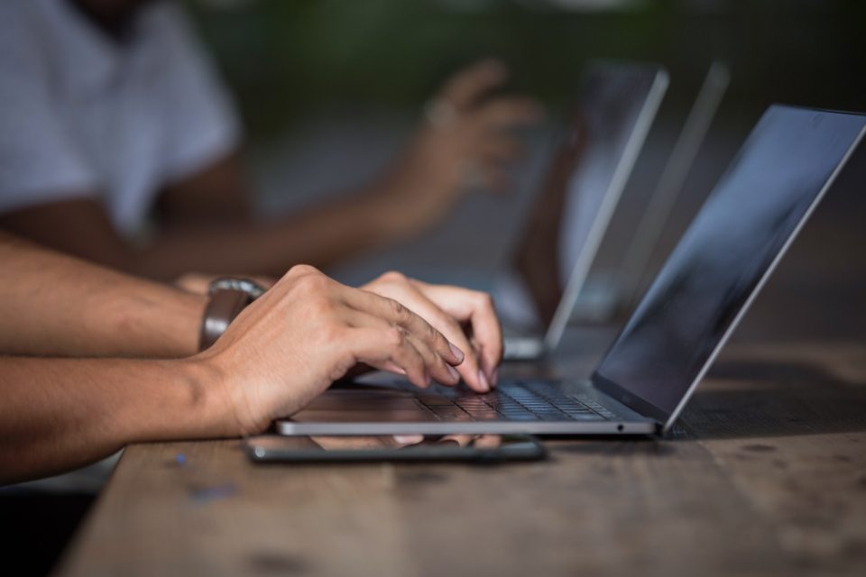 Dłonie piszące na klawiaturze laptopa