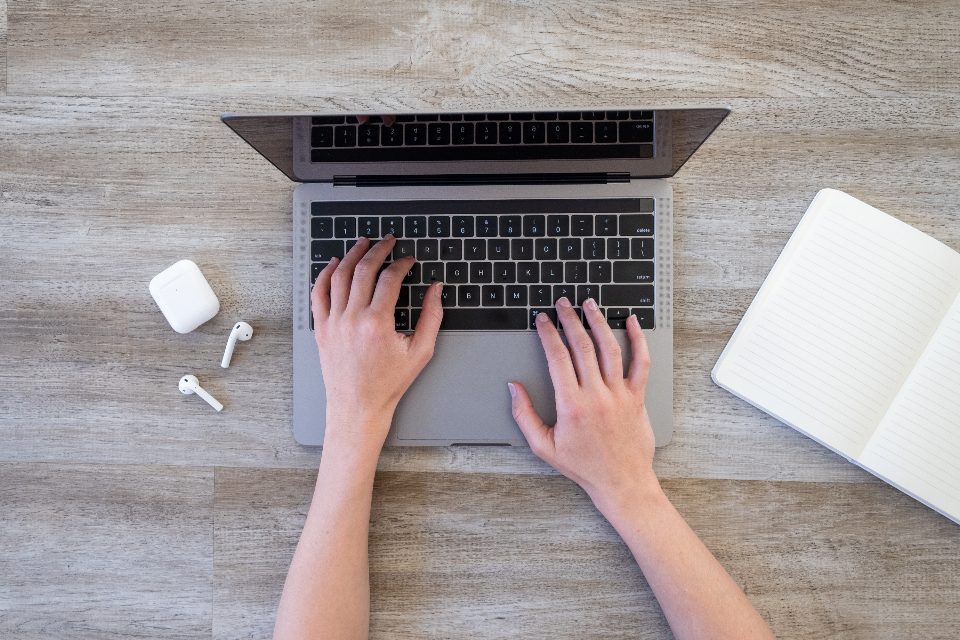 Osoba pracująca na laptopie przy biurku